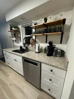 a kitchen with white cabinets and a counter top at Historic Retreat on Eola + Private Hot Tub + Grill in Orlando
