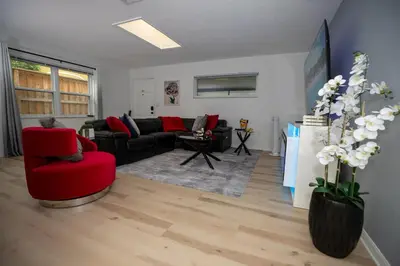 a living room with a red chair and a couch at Eola Retreat Private Hot Tub with Grill in Orlando