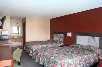 a hotel room with two beds and a table at Oak Ridge Inn in Kissimmee