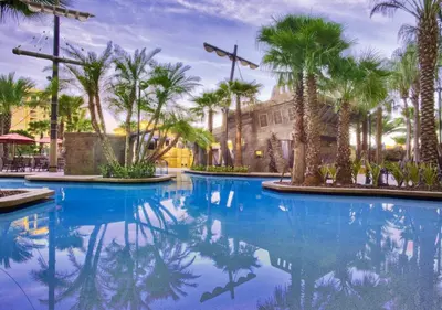 a pool with palm trees and a building at Wyndham Bonnet Creek 1BR Apartment with Resort Access in Orlando