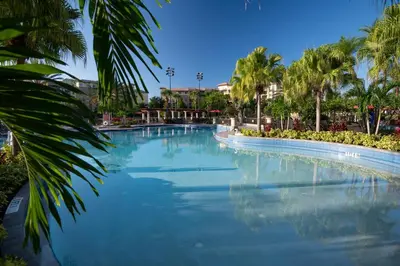 a large swimming pool with palm trees in a resort at Wyndham Bonnet Creek 2BR Apartment with Resort Access in Orlando