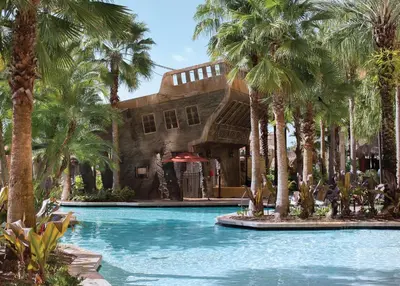 a swimming pool with palm trees in front of a building at Wyndham Bonnet Creek 3BR Apartment with Resort Access in Orlando