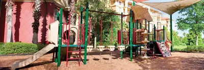 a playground in front of a pink building with a slide at Wyndham Bonnet Creek 3BR Apartment with Resort Access in Orlando