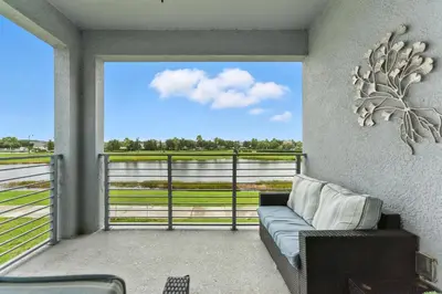 a living room with a couch on a balcony at Beautiful Lakeview Retreat Near Disney in Kissimmee