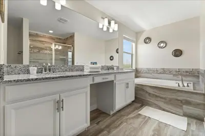 a white bathroom with a tub and a sink and a bath tub at 6 Bedrooms 5 Bathrooms Storey Lake 4763Kc in Kissimmee
