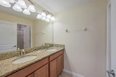 a bathroom with two sinks and a large mirror at Casa 4 Quartos c/ Piscina – 10 Min da Disney in Kissimmee