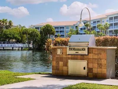 a barbecue grill sitting next to a body of water at Sheraton Vistana Villages 2BR Apartment with Resort Access in Orlando