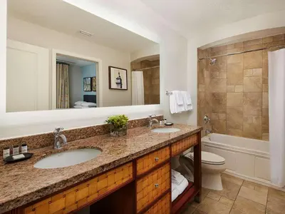 a bathroom with two sinks and a toilet and a mirror at Sheraton Vistana Villages 2BR Apartment with Resort Access in Orlando