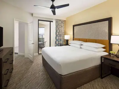 a bedroom with a large white bed with a ceiling fan at Sheraton Vistana Villages 2BR Apartment with Resort Access in Orlando