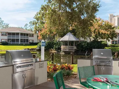 a patio with a grill and a table and chairs at Sheraton Vistana Resort One Bedroom Apartment in Orlando