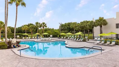 a pool at a resort with chairs and umbrellas at Marriott's Sabal Palms 2BR Apartment with Resort Access in Orlando