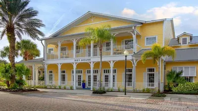a yellow building with palm trees in front of it at Marriott's Harbour Lake 1BR Apartment with Resort Access in Orlando