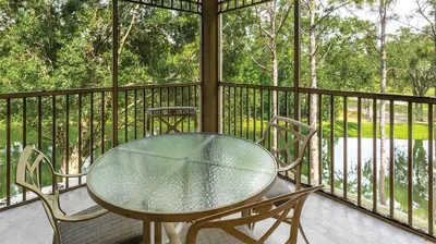 a glass table and two chairs on a balcony at Marriott's Imperial Palms 3BR Apartment with Resort Access in Orlando