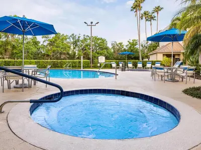 a pool with umbrellas and tables and chairs at Marriott's Imperial Palms 3BR Apartment with Resort Access in Orlando
