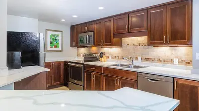 a kitchen with wooden cabinets and a sink at Marriott's Royal Palms 2BR Apartment with Resort Access in Orlando