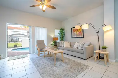 a living room with a couch and a table at Charming 3BR Resort Townhome with Private Pool near Disney in Kissimmee