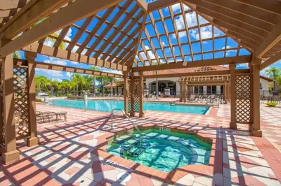 an outdoor swimming pool with a large wooden pergola at Charming 3BR Resort Townhome with Private Pool near Disney in Kissimmee