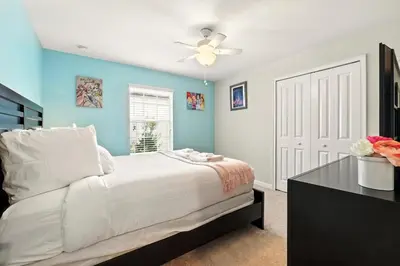 a bedroom with a white bed and a ceiling fan at Vibrant 5BR Family Retreat in Storey Lake in Kissimmee
