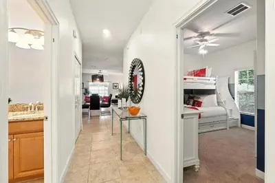 a living room with a table and a bedroom at Vibrant 5BR Family Retreat in Storey Lake in Kissimmee