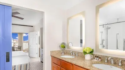 a bathroom with two sinks and a bedroom at Marriott's Grande Vista 1BR Apartment with Resort Access in Orlando