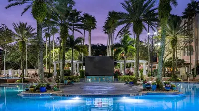 a large pool with palm trees and a screen at Marriott's Grande Vista 1BR Apartment with Resort Access in Orlando