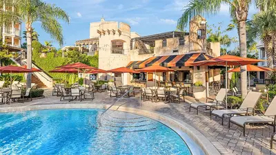 a resort pool with chairs and tables and umbrellas at Marriott's Grande Vista 2BR Apartment with Resort Access in Orlando