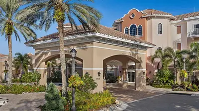 a house with a palm tree in front of a street at Marriott's Grande Vista 2BR Apartment with Resort Access in Orlando