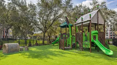 a park with a playground with slides and a building at Marriott's Grande Vista 2BR Apartment with Resort Access in Orlando
