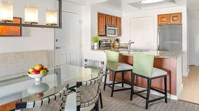 a kitchen with a glass table and chairs at Marriott's Grande Vista 3BR Apartment with Resort Access in Orlando