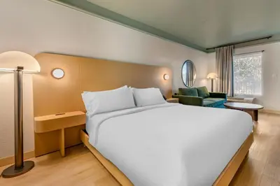 a large white bed in a hotel room at voco Kissimmee Orlando by IHG in Orlando