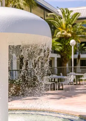 a fountain in a courtyard with tables and chairs at voco Kissimmee Orlando by IHG in Orlando