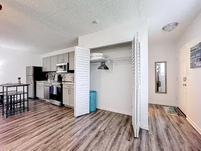 a kitchen with white cabinets and a table in a room at Comfy Studio Farm Stay in Orlando