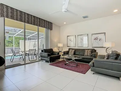 a living room with couches and chairs and a table at Harmony in Orlando