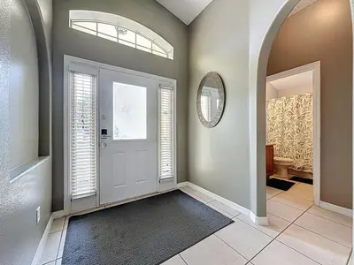 a hallway with a door with a mirror and a window at Casa del Sol at Indian Creek Four Corners villa in Kissimmee