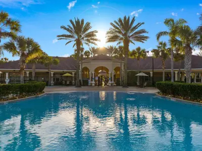 a swimming pool in front of a house with palm trees at Disney Home in Orlando