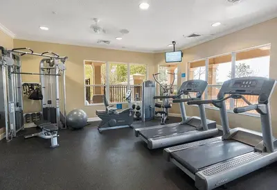 a gym with treadmills and machines in a room at Disney Home in Orlando
