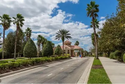 an empty street with palm trees and a house at Disney Home in Orlando