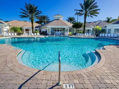 a swimming pool at a resort with palm trees at Perfect Disney Resort Condo in Kissimmee