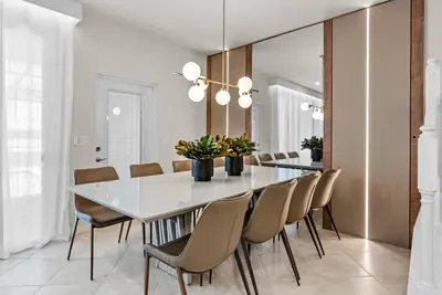 a dining room with a white table and chairs at Brand NEW 05 Bedrooms At Windsor Cay in Orlando