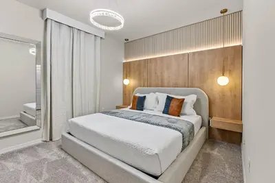 a bedroom with a large bed and a mirror at Brand NEW 05 Bedrooms At Windsor Cay in Orlando