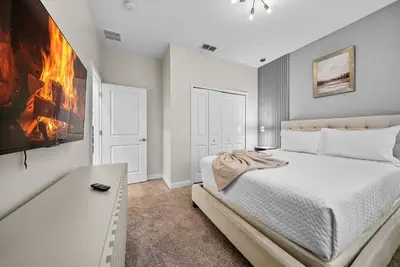a white bedroom with a bed and a table at Brand NEW 05 Bedrooms4 Baths At Storey Lake in Kissimmee