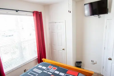 a bedroom with a bed and a tv and a window at NEW - Paradise townhome at Windsor Hills in Orlando
