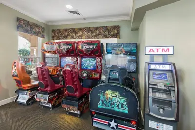 a room with a bunch of arcade games and consoles at NEW - Paradise townhome at Windsor Hills in Orlando