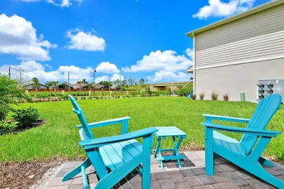 two blue chairs and a table on a patio at Paradise Breeze Cottage by Shine Villas - Margaritaville Resort Orlando condo in Orlando