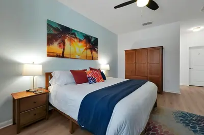 a bedroom with a large bed and a dresser with a night stand at Enchanted Escape-Perfect Pool to Relax & Recharge in Kissimmee