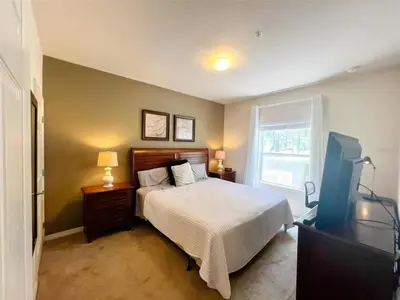 a bedroom with a bed and a tv and a window at 4 Bedrooms 3 Bathrooms Lucaya 10-108 in Kissimmee