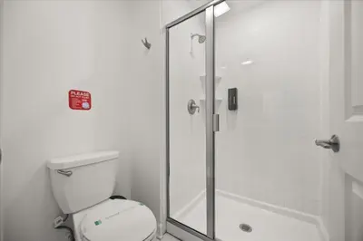 a bathroom with a toilet and a glass shower at 4 Bedrooms 3 Bathrooms Storey Lake 2952 Ps in Kissimmee