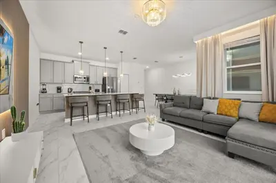a living room and kitchen with a couch and a table at 4 Bedrooms 3 Bathrooms Storey Lake 2952 Ps in Kissimmee