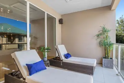a patio with two white chairs and a window at 4 Bedrooms 45 Bathrooms Magic Village7603Rd in Orlando