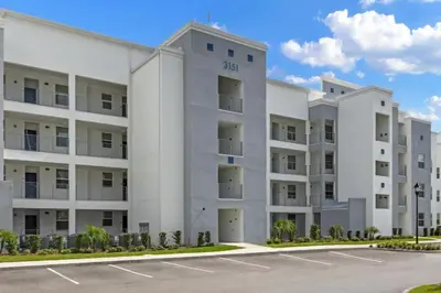 an apartment building with a parking lot at 2 Bedrooms 2 Bathrooms Storey Lake 3151-404 in Kissimmee